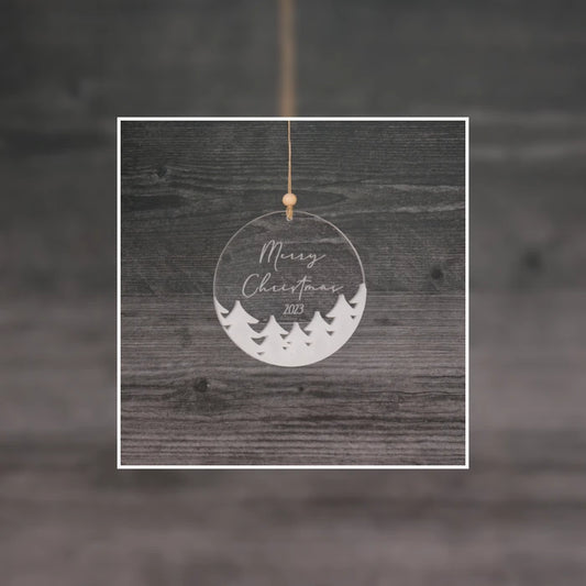 Laser-engraved acrylic Christmas ornament made from Clear Cut Acrylic’s premium clear acrylic sheet, featuring “Merry Christmas 2023” with festive evergreen trees. Hung by a wooden bead and twine, this holiday decor piece showcases the clarity and clean edges achieved through laser cutting. A great example of how Clear Cut Acrylic is used by crafters, Etsy sellers, and small businesses to create personalized holiday gifts and seasonal products with a modern, elegant finish. 2