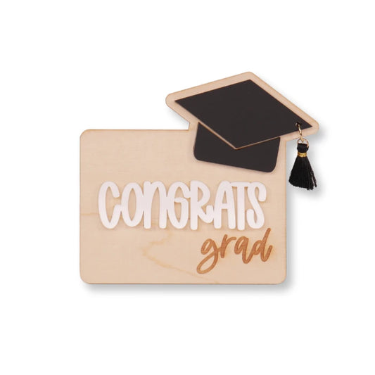 Graduation-themed gift card holder made of wood with layered acrylic lettering and a cap detail, reading “Congrats Grad.” This is an example of what could be made with Clear Cut Acrylic’s white acrylic sheets for custom holiday or milestone gifts. The laser-cut acrylic text adds dimensional flair and personalization to the piece, making it a perfect project for crafters, small business sellers, and gift makers preparing unique designs for graduation season. 5